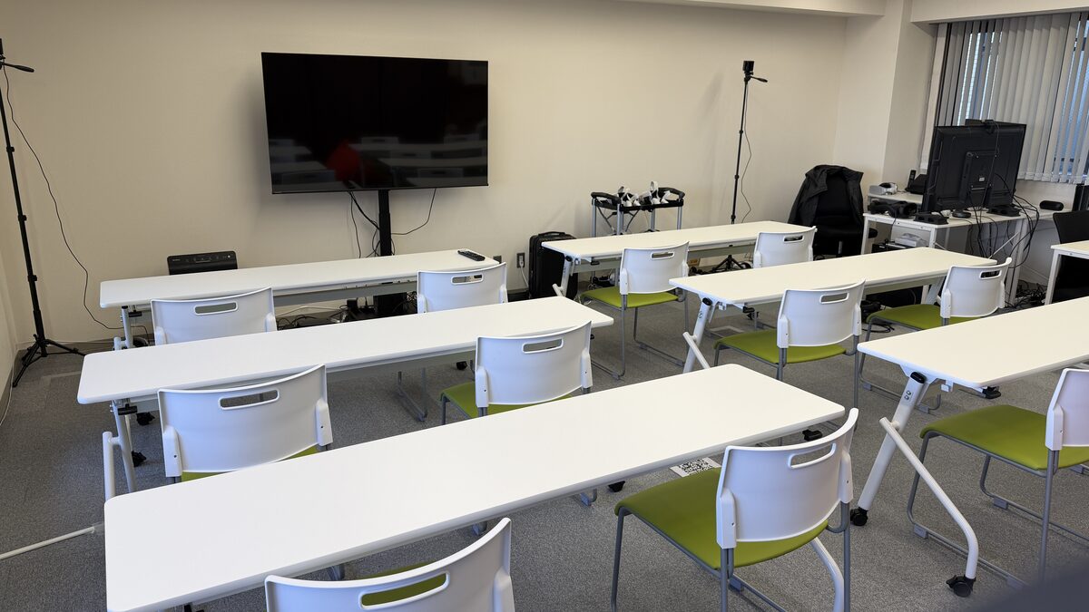 A meeting room with long tables and chairs